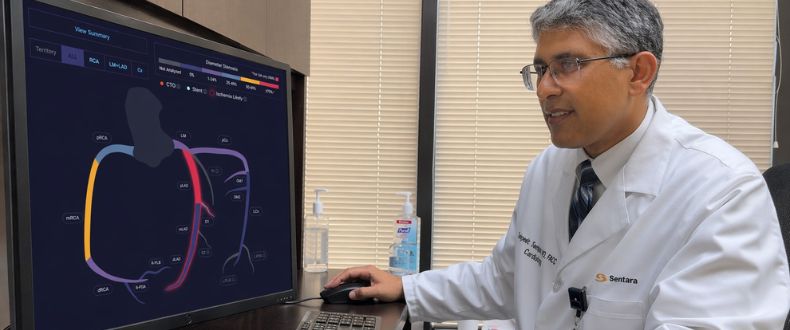 Clinician reviewing a vascular blood flow visualization on a computer monitor in a medical office.