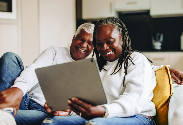 Happy senior couple smiling cheerfully while having a video call on a digital tablet