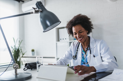 smiling provider using a tablet at desk