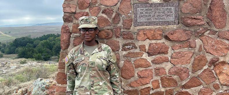 Shaunice Johnson poses against a wall, dressed in her U.S. army uniform. 
