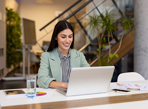 Business person seated at desk using laptop