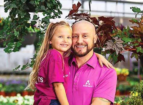 Man with a work shirt on holding a little girl