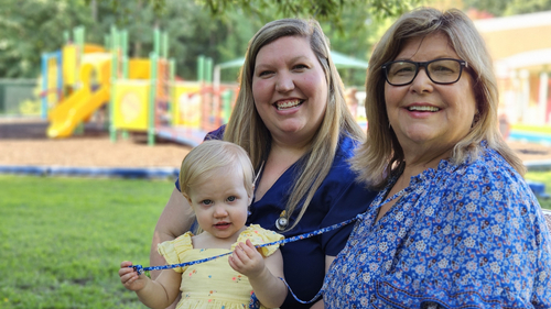 Emma Doughtie (left) sits outdoors with her young daughter and her mother, Rita Salmon (right), at a playground near Sentara Obici Hospital.