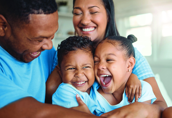 A father, mother, and two children laughing