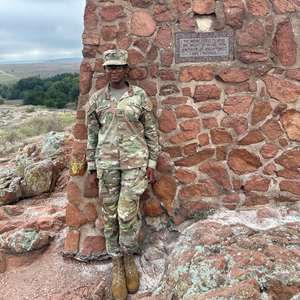 Shaunice Johnson poses against a wall, dressed in her U.S. army uniform. 