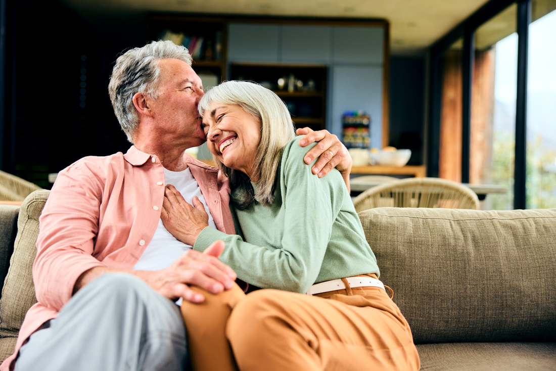 senior couple laughing on couch
