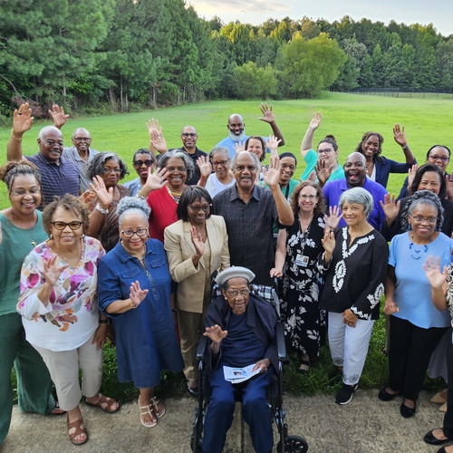 A group of people smiling and waving at the camera outside of Eastend Baptist Church in Suffolk, Virginia. 