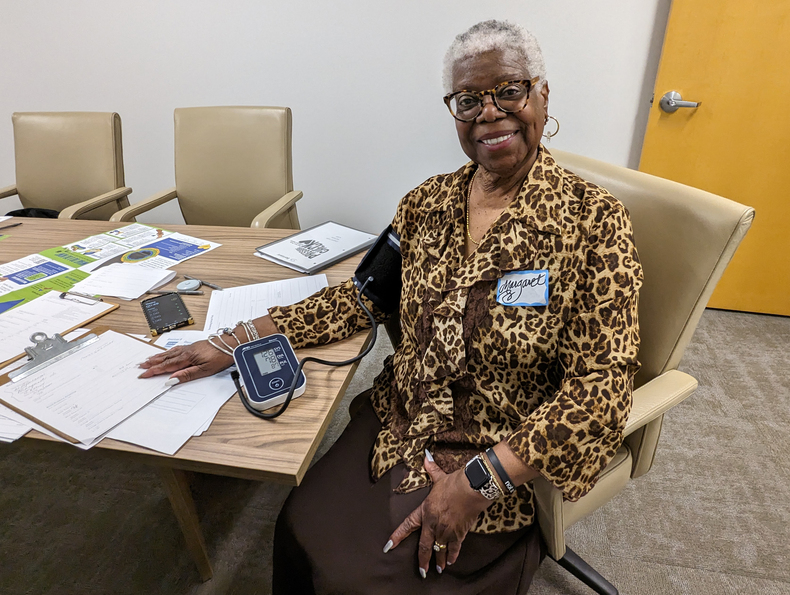 Margaret Collins smiles after checking blood pressure as part of Sentara study.jpg