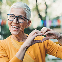 Smiling Woman Making Heart with Hands