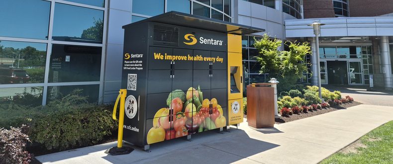 A Sentara-branded refrigerated food locker stands outside the emergency department entrance of Sentara Obici Hospital in Suffolk, Virginia, available around the clock to provide fresh food to patients and community residents in need.