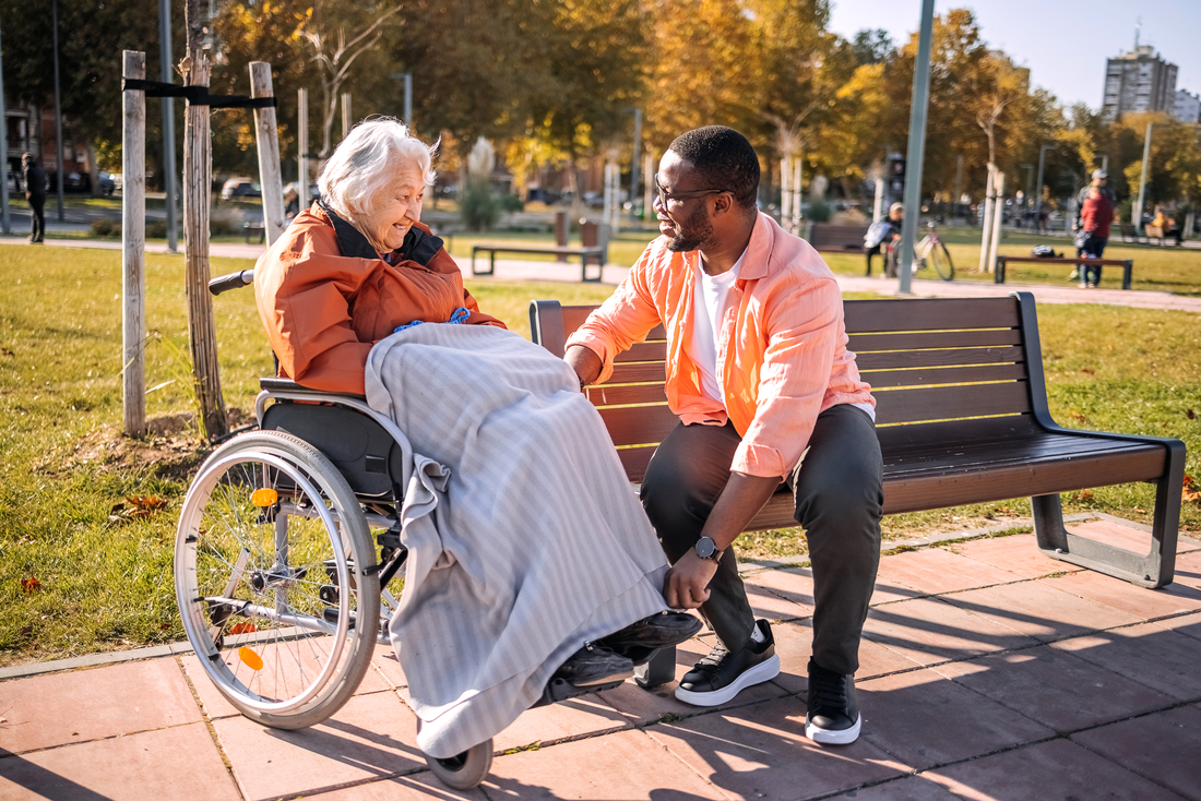 volunteer helping woman with wheelchair blanket