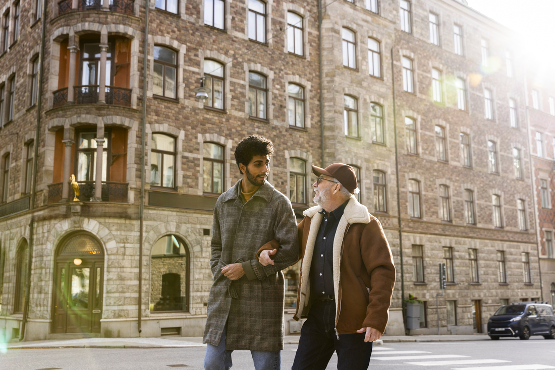 son walking down street with elderly father