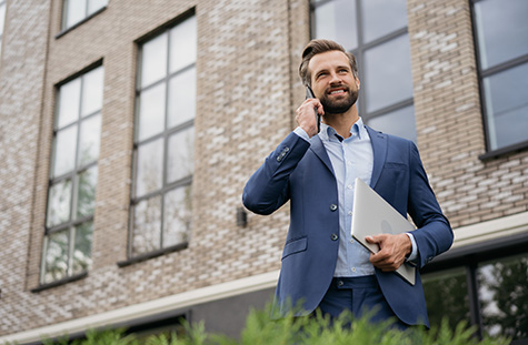 man-on-phone-holding-laptop.jpg