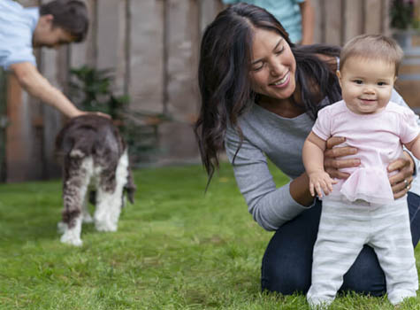 Woman holding baby in a backyard