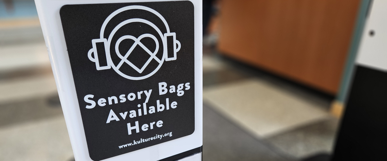 A sign in the entrance of a Sentara hospital indicates that sensory bags are available in the hospital to help create a more comfortable, accessible experience for patients and visitors with sensory sensitivities.