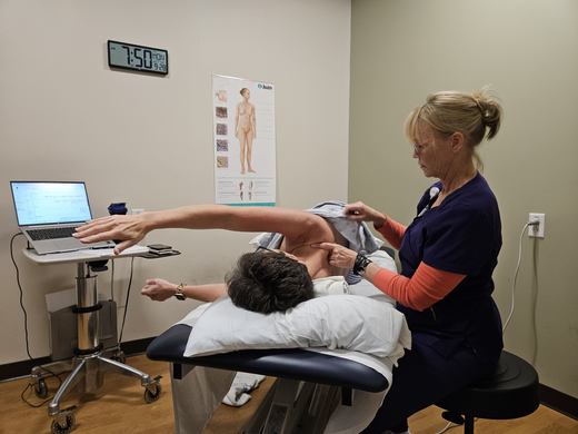 Fran Peed stretches her arms forward as Mary Piazza, an occupational therapist at Sentara Brock Cancer Center, guides her through exercises focused on mobility and healing after her mastectomy.