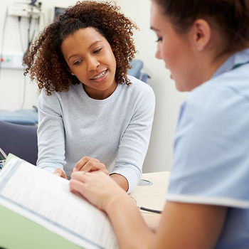 Healthcare provider reviewing treatment information with a patient during a vein care consultation.