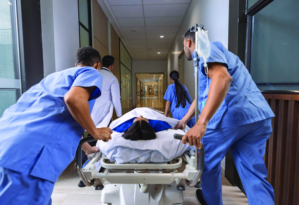 Healthcare team rapidly transports a patient on a hospital stretcher through a corridor to receive emergency medical care.