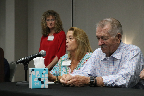 Linda Barnes speaks at a panel during the 6th Annual Sentara Stroke Symposium as her husband Herbert Barnes listens and Andrea Helmbach looks on from the background.