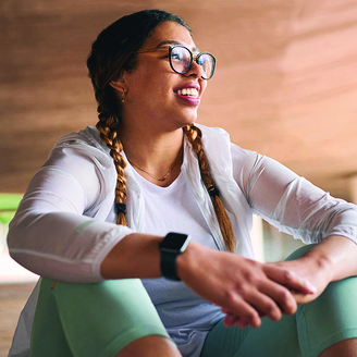 smiling woman sitting with exercise clothing on