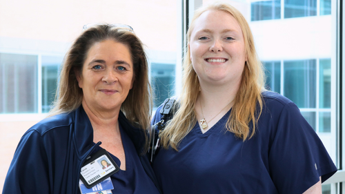 Cassie Verlander (left) and her daughter, Meghan Nowell, smile together in navy blue scrubs at Sentara CarePlex Hospital, where both work as nurses.