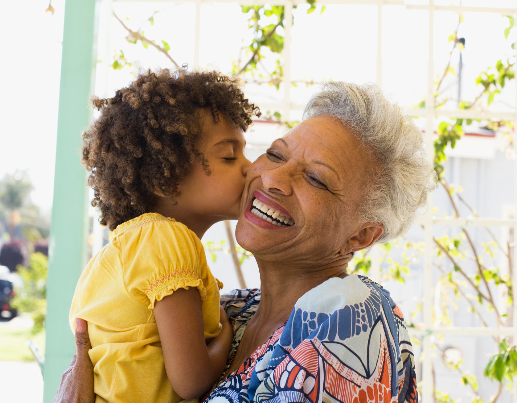 granddaughter kissing grandmother on cheek