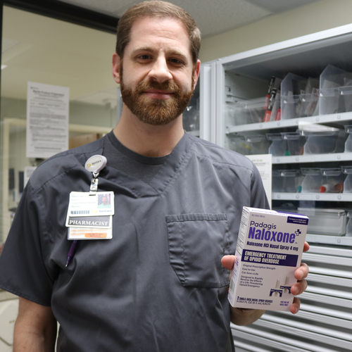 Marcus Kaplan, a clinical pharmacy specialist at Sentara Norfolk General Hospital, holds a box of naloxone.