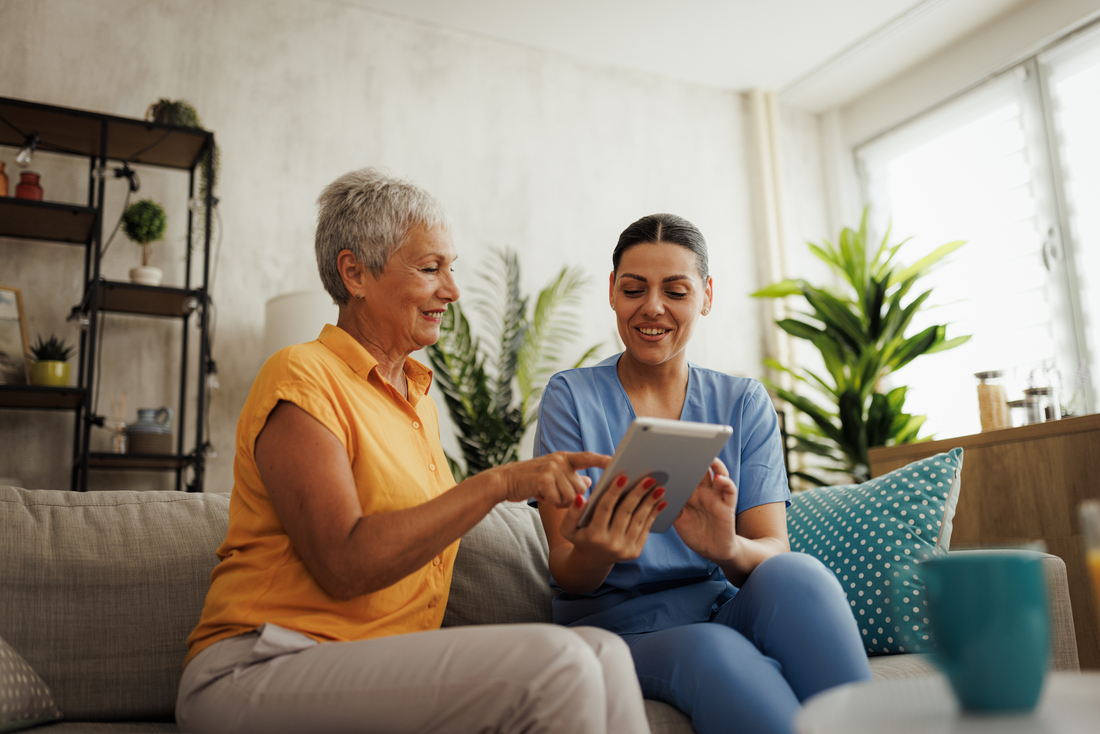 home nurse showing senior woman tablet