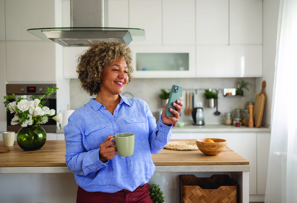Women standing in kitchen on her phone