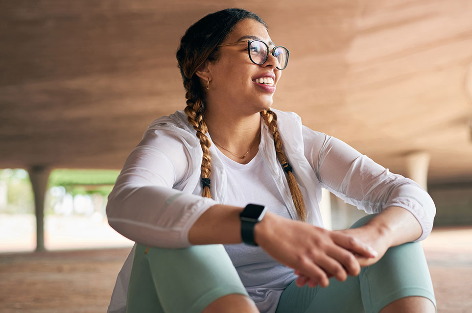 smiling woman sitting with exercise clothing on