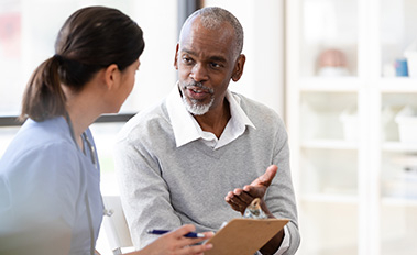 Older man talking with a healthcare provider during a medical appointment