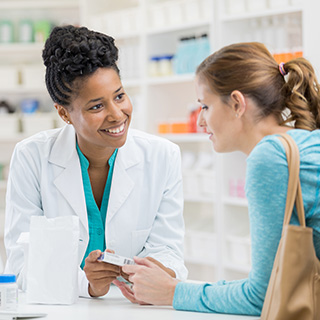 pharmacy tech handing medication to patient