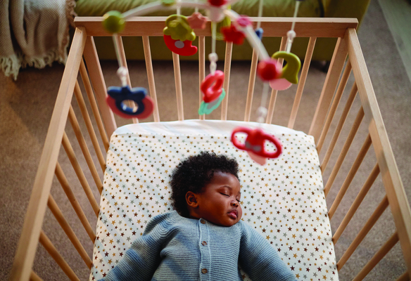 A baby sleeping safely in her crib