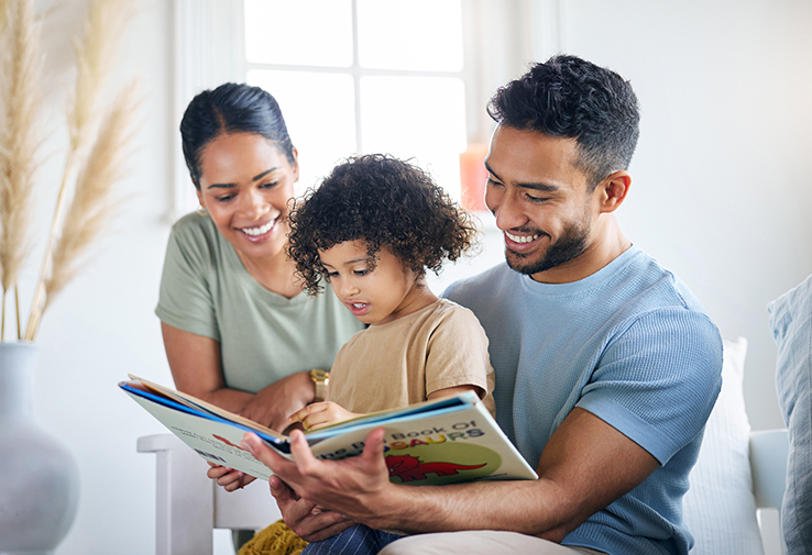 Family of three reading a book together