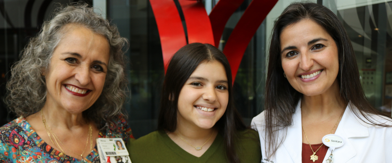 Mirna Medina-Gonzalez (left) stands with her granddaughter, Victoria (center), and daughter, Maxine Morales (right), in the lobby at Sentara Norfolk General Hospital, representing three generations of a family connected by nursing at Sentara.