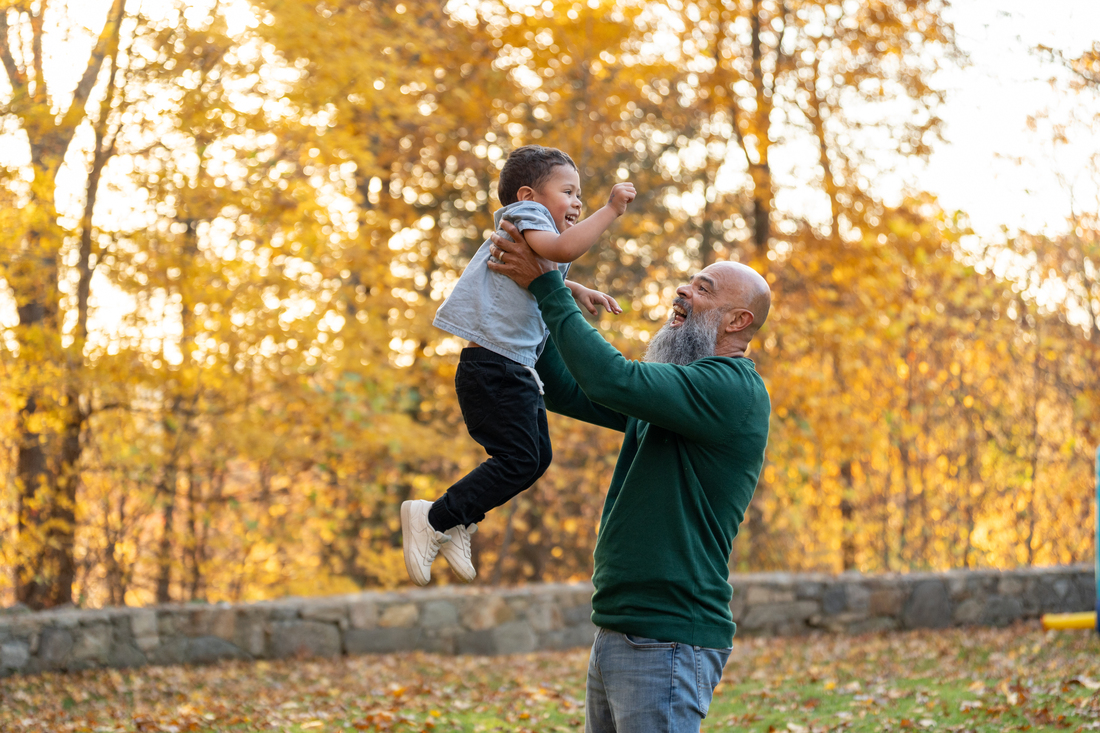 grandfather and grandson playing outdoors in autumn