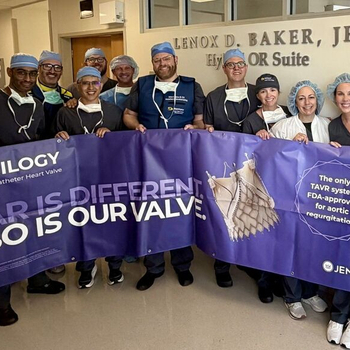 The Sentara Structural Heart Team poses in a hospital hallway in surgical scrubs and caps, holding a large purple JenaValve banner marking the first commercial use of the Trilogy® Transcatheter Heart Valve system — the only FDA-approved TAVR for aortic regurgitation — in Virginia. The sign behind them reads "Lenox D. Baker, Jr. Hybrid OR Suite."