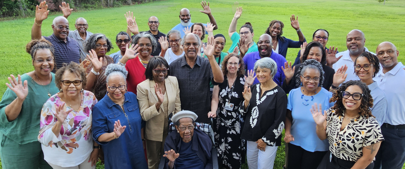 A group of people smiling and waving at the camera outside of Eastend Baptist Church in Suffolk, Virginia. 
