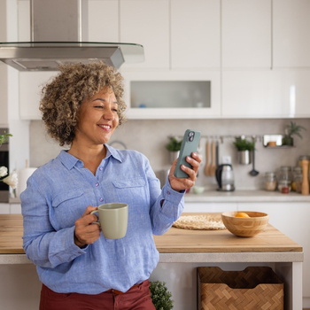 Women standing in kitchen on her phone