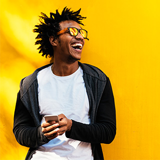 man holding phone smiling yellow background.jpg