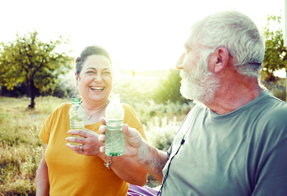 older couple drinking water on a walk