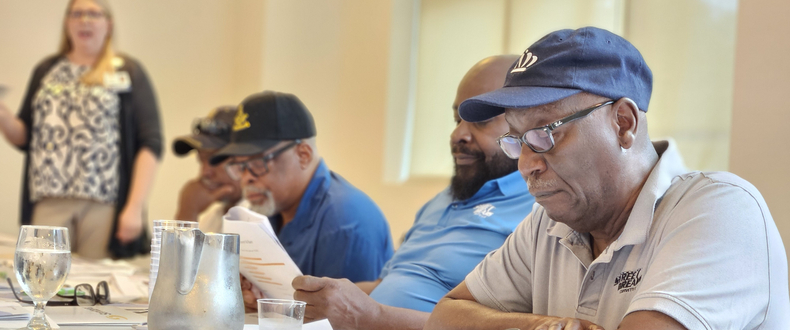 Betsy Carroll (left), cancer community educator, speaks with men in the Street Dreams Corvette Club about prostate cancer